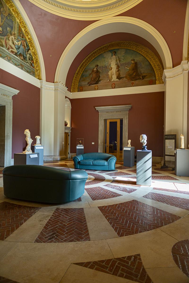 the interior of a 19th century rotunda showing ancient sculptures and lunette murals